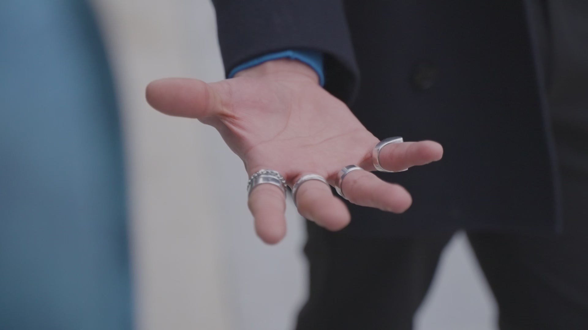 Un homme rattrape un téléphone de manière charismatique. Le téléphone est vêtu d'une coque Hibisca La coque a pour façade des fleurs de bleuet compressées et très jolie à voir. La coque est de couleur bleu. L’homme tenant le téléphone a une belle main ornée de bague sur chacun de ses doigts. Il porte également un très beau costume noir avec un tee-shirt élégant bleu rois.